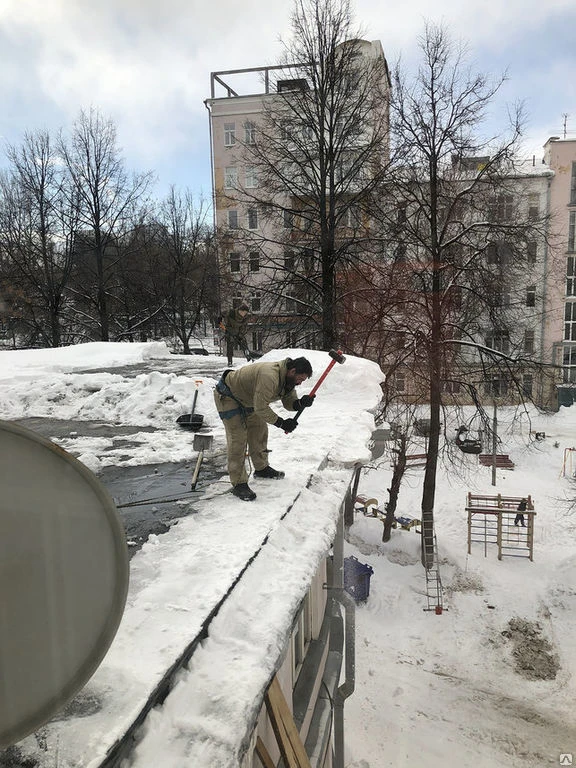 Фото Уборка снега с крыши плоской